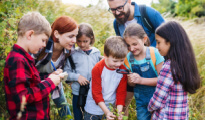 students inspecting something on a field trip outside 