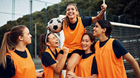 A women's soccer team celebrate a win