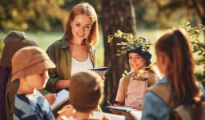 A teacher smiling at students on a field trip 