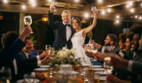 A bride and groom standing to toast