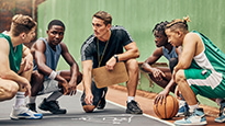 A basketball team huddles during practice