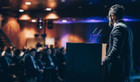 a speaker on stage at a business conference 