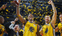 a men's basketball team celebrating with falling confetti 