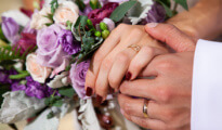 close up of a couple holding hands with a wedding bouquet