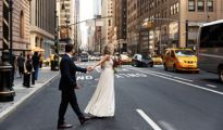 New York City newlywed couple crossing the street in the busy city.