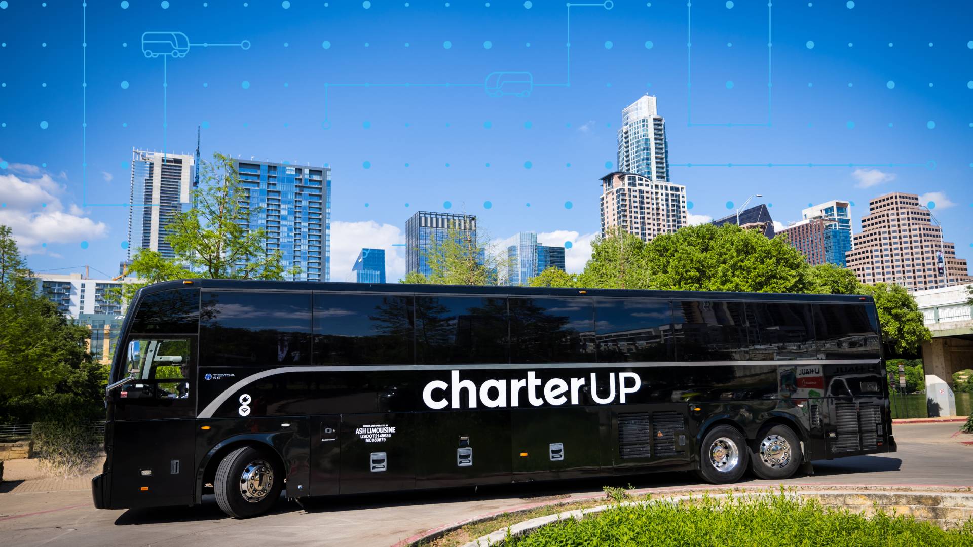 A CharterUP bus parks in front of the Austin skyline to announce the startup's new headquarters in the Innovation Corridor.