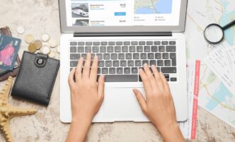 A travel agent searches on a laptop for charter bus rentals