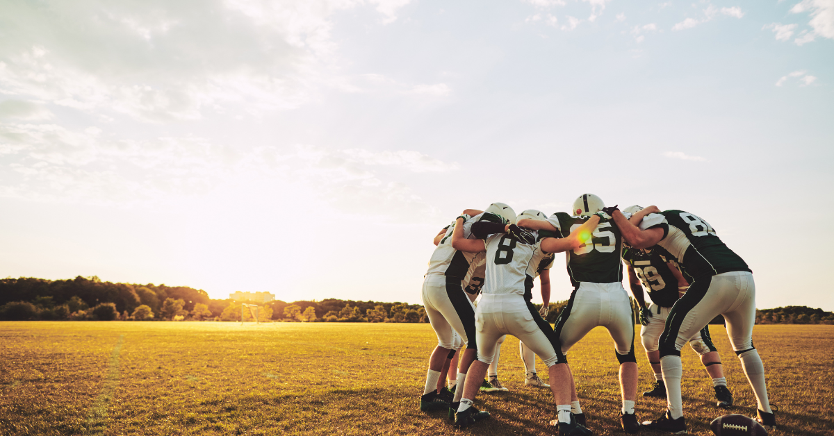 A football team huddled on the field.