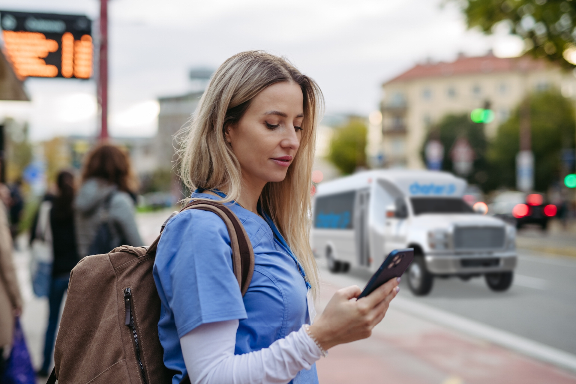 A nurse waits for a CharterUP shuttle after a shift